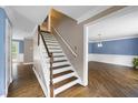 Staircase with hardwood treads leading to the upper level, next to a room with natural light at 2108 Yorkshire Ct, Woodstock, GA 30189