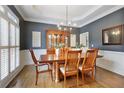 Dining room with hardwood floors, white wainscoting, and a modern chandelier at 610 Woodstream Ct, Roswell, GA 30075