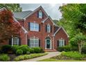 Beautiful brick home featuring mature trees, a lush front lawn, and charming curb appeal at 610 Woodstream Ct, Roswell, GA 30075