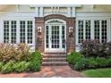 Close up of brick archway front entrance with brick steps, sidelight windows, and manicured landscaping at 16 Walker Ne Ter, Atlanta, GA 30309