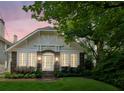 Charming brick home with arched entryway, large windows, and lush landscaping at dusk at 16 Walker Ne Ter, Atlanta, GA 30309