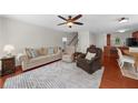 Spacious living room featuring hardwood floors, a ceiling fan, and ample seating at 397 Cypher Dr, Suwanee, GA 30024
