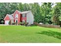 Beautiful home with a large lawn, complemented by mature trees offering ample shade at 630 Beckenham Walk Dr, Dacula, GA 30019