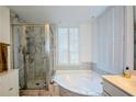 This bathroom features a glass shower and large soaking tub surrounded by beautiful marble and tile at 1315 Mcgill Park Ne Ave, Atlanta, GA 30312