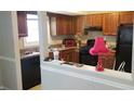 View of the kitchen featuring brown cabinets, a black refrigerator and updated appliances at 687 Redland Dr # 687, Riverdale, GA 30238