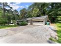 A one-story home with an attached garage and a wide driveway at 1467 Hewatt Rd, Lilburn, GA 30047