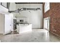 Open-concept living area with exposed brick, tall ceilings, and a modern kitchen at 791 Wylie Se St # 404, Atlanta, GA 30316