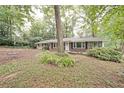 Charming brick home featuring a well-maintained front yard with mature trees and a cozy, inviting exterior at 1327 Rupert Rd, Decatur, GA 30030