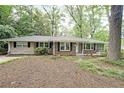 Charming brick home featuring a well-maintained front yard with mature trees and a cozy, inviting exterior at 1327 Rupert Rd, Decatur, GA 30030