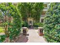 Entrance to Exeter condos via brick path. Signage on brick pillars. Mature trees and landscaping at 2 Collier Nw Rd # 5, Atlanta, GA 30309