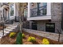 Charming brick townhome featuring a front porch, landscaped garden and black metal railings at 540 Fisher Dr # 46, Alpharetta, GA 30009