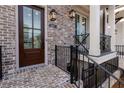 Charming brick townhome featuring a front porch and black metal railings at 540 Fisher Dr # 46, Alpharetta, GA 30009