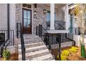 Charming brick townhome featuring a front porch, landscaped garden and black metal railings at 540 Fisher Dr # 46, Alpharetta, GA 30009