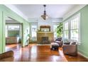 Bright living room featuring hardwood floors, a decorative fireplace, large windows, and stylish chairs with ottoman at 570 Park Se Ave, Atlanta, GA 30312