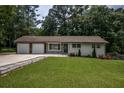 Ranch style home with a brick and wood facade and a green lawn at 905 Hickory Ridge Sw Rd, Lilburn, GA 30047