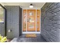 Modern front door with glass panels, set against a stone and brick exterior with matte black accents at 3008 Ridgeside Ct, Atlanta, GA 30341