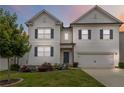 Charming two-story home featuring white siding, blue shutters, and a well-manicured lawn at dusk at 4000 Red Canoe Bnd, Lilburn, GA 30047