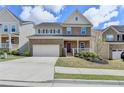 Inviting two-story brick home with a charming front porch, manicured lawn, and a convenient two-car garage at 4349 Northmark Ln, Buford, GA 30518