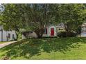 Home exterior with a well-manicured lawn and lush trees, and a bright red front door at 1932 Neely Ave, Atlanta, GA 30344