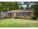 Brick house with manicured lawn and brick walkway to front door, black shutters adorn windows at 59 Oakmont Nw Dr, Marietta, GA 30064