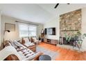 Cozy living room featuring a stone fireplace, leather sofa, and hardwood floors at 8 Southview Dr, Cartersville, GA 30121