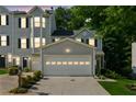 Attractive townhome featuring a two-car garage, classic siding, and landscaped front yard at twilight at 1714 Indian Way, Cumming, GA 30040
