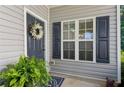 Welcoming front entrance with a wreath, green ferns, a sidelight window, and black shutters at 1714 Indian Way, Cumming, GA 30040
