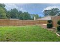 Spacious backyard featuring a tall wood privacy fence, green grass and mature trees at 1150 Terramont Dr, Roswell, GA 30076