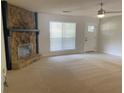 Bright living room with plush carpet, ceiling fan and a stone fireplace at 1150 Terramont Dr, Roswell, GA 30076