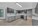 Modern kitchen featuring gray lower cabinets, dark upper cabinets, stainless steel appliances, and stone countertops at 63 Lakeview Ln, Stockbridge, GA 30281