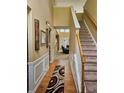 Inviting entryway with hardwood floors, elegant wainscoting, and a staircase leading to the upper level at 1697 Preserve Park Dr, Loganville, GA 30052