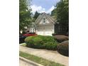 Two-car garage providing ample parking space, complemented by lush greenery and a neatly maintained lawn at 1697 Preserve Park Dr, Loganville, GA 30052