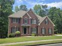 Beautiful two-story brick home showcases classic architectural details and mature landscaping at 1988 Greensferry Gln, Lawrenceville, GA 30043