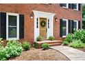 Charming brick home entrance with a decorative wreath and manicured landscaping at 4522 Reva Ne Ct, Marietta, GA 30066