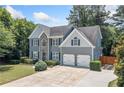 Beautifully landscaped home showcasing a well-manicured lawn, stone accents, and a two-car garage at 2081 Township Dr, Woodstock, GA 30189