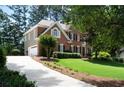 Lovely two-story brick home with a long driveway and attached two-car garage at 410 Beechwood Ln, Woodstock, GA 30189