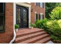 Welcoming brick entryway features an ornate black double door and brick steps at 410 Beechwood Ln, Woodstock, GA 30189