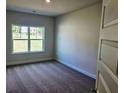A cozy bedroom with new carpet and a bright window offering natural light and serene views at 112 Scarlett Place Dr, Bowdon, GA 30108