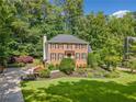 Classic brick home with black shutters, lovely landscaping, and a serene, wooded backdrop at 2502 Tritt Springs Ne Trce, Marietta, GA 30062