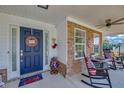 Welcoming front porch featuring patriotic decor, rocking chairs, and brick accents at 5105 Ashley Falls Ct, Loganville, GA 30052