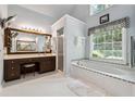 Bright bathroom featuring soaking tub, separate shower, and vanity with generous counter space at 2505 Ridgehurst Dr, Buford, GA 30518