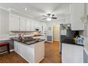 Well-lit kitchen featuring a central island with sleek black countertop and white cabinetry at 2505 Ridgehurst Dr, Buford, GA 30518