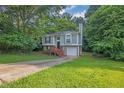Charming split-level home with gray siding, brick accents, and a one-car garage nestled in lush greenery at 3498 Newberry Trl, Decatur, GA 30034