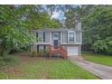 Charming split-level home with gray siding, brick accents, and a one-car garage nestled in lush greenery at 3498 Newberry Trl, Decatur, GA 30034