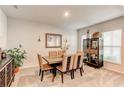Bright dining room featuring neutral carpet, furniture, cabinet, a mirror, and natural light from the window at 230 Mackenzie Ct, Covington, GA 30016