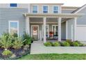 Inviting front porch with classic columns, a seating area, and a decorative wreath on the front door at 230 Mackenzie Ct, Covington, GA 30016
