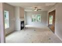 A spacious living room with a fireplace, ceiling fan, and windows creates a bright, inviting space at 309 Melanie Ct, Bowdon, GA 30108