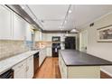 Bright, updated kitchen with island, white cabinets, track lights, and modern appliances at 159 Cavan Se Way, Mableton, GA 30126
