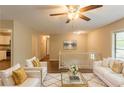 Bright living room featuring modern decor, white couches with gold pillows, and stylish ceiling fan at 4669 Birch Ridge Trl, Stone Mountain, GA 30083