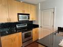 Kitchen boasts stainless appliances, black granite countertops and tile backsplash at 361 17Th Nw St # 1303, Atlanta, GA 30363